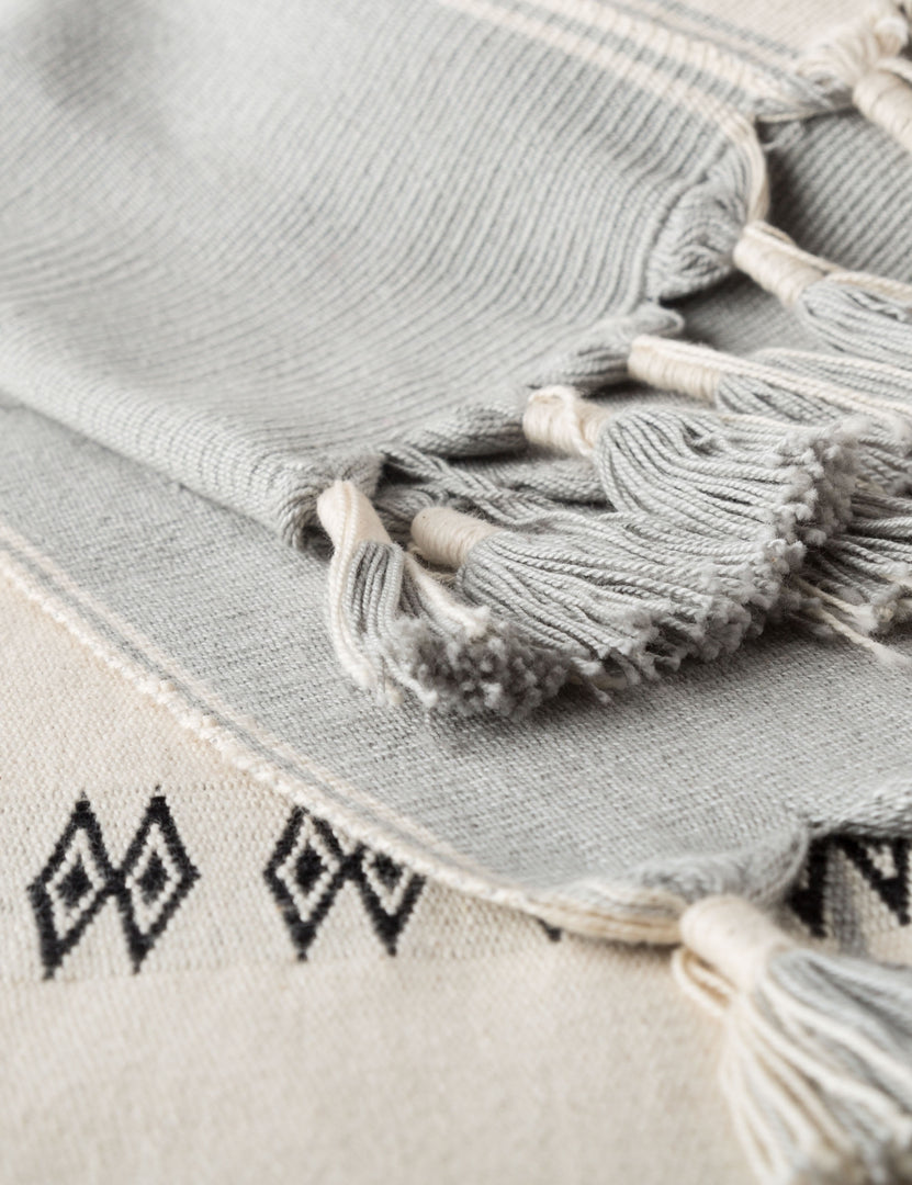 | Close-up of the tasseled edges on the Halia gray and white geometric throw blanket