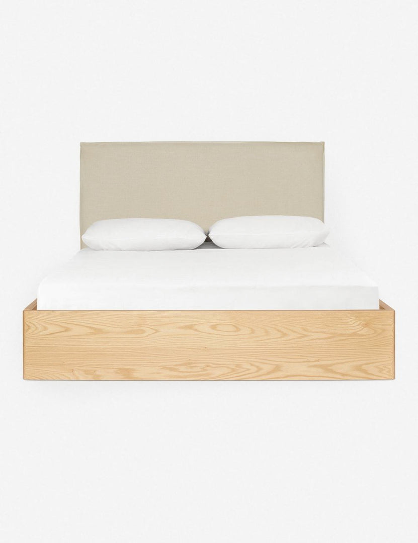 #size::cal-king #size::king #color::natural #size::queen | Nia bed with a wrap-around neutral wooden base and a natural linen rectangular headboard