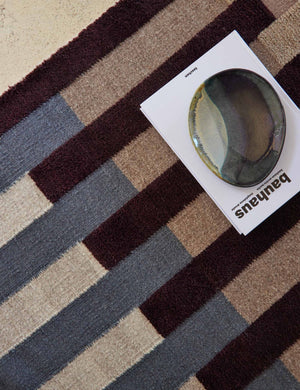 Bird's-eye view of the otti rug with a book and multi-colored bowl sitting atop it