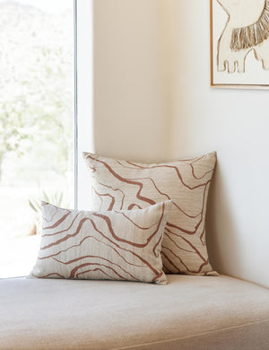 Canyon Terracotta Lumbar and Square Pillows sit on a cushioned white bench