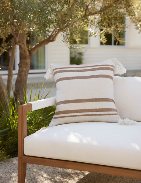 #color::camel | The Fez camel and white indoor and outdoor throw pillow sits on a white sofa in an outdoor space