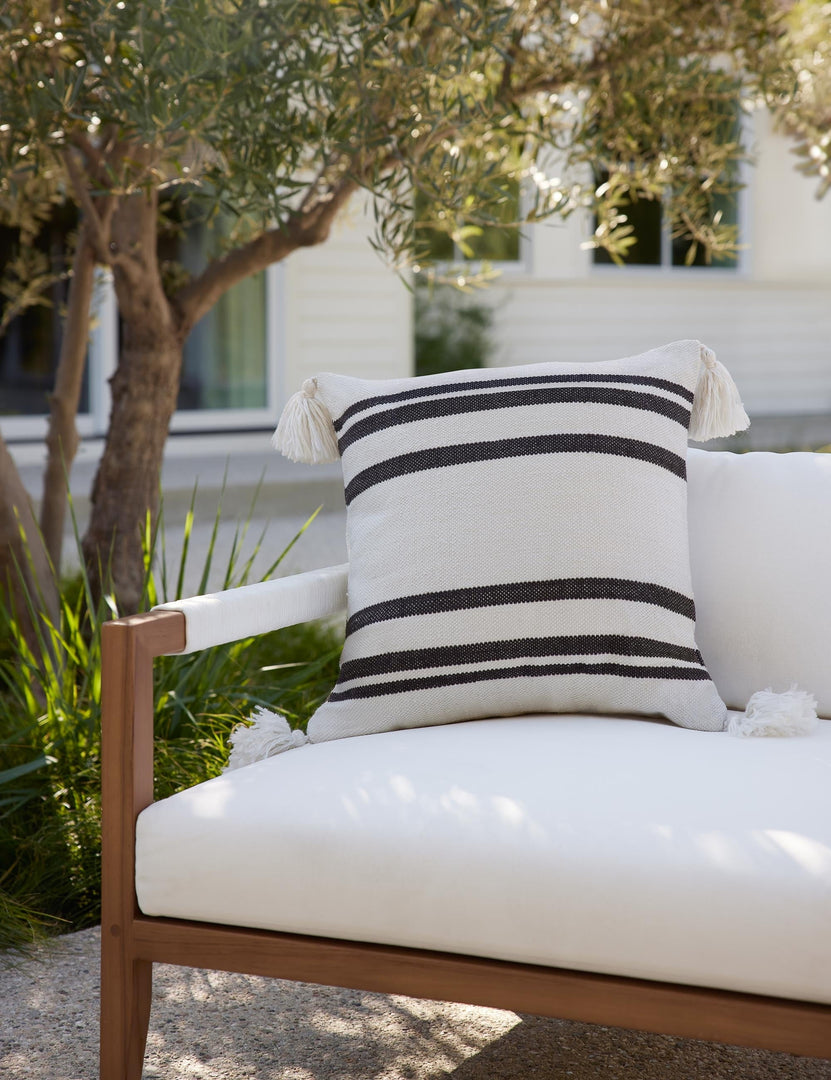 #color::black | The Fez black and white indoor and outdoor throw pillow sits on a white sofa in an outdoor space
