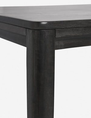 Close-up of the rounded corner of the Reese black mango wood rectangular dining table.