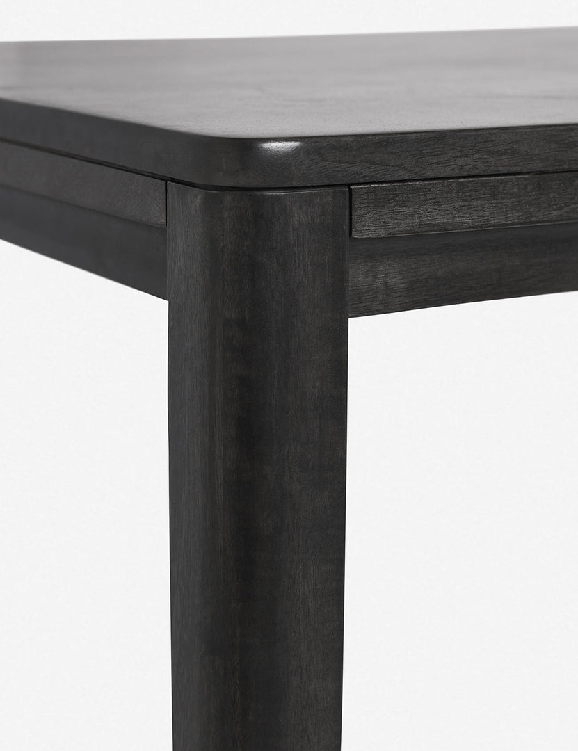 #color::black #size::82-W | Close-up of the rounded corner of the Reese black mango wood rectangular dining table.