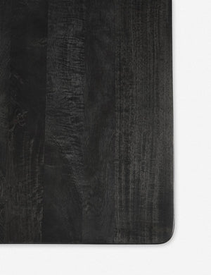 Detailed birds-eye shot of the black mango wood on the Reese black mango wood rectangular dining table.