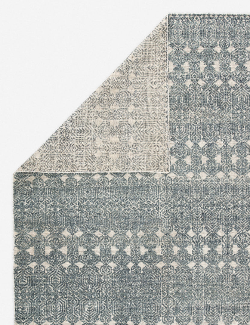 #size::5--x-8- #size::8--x-11- #color::teal-and-light-gray #size::9--x-13- | Close-up of the folded corner of the Carleigh hand-knotted blue-gray patterned Rug
