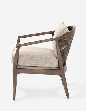 Side view of Rhea accent chair with natural-toned cushions and curved wicker back