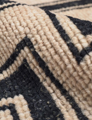 Close-up of the woven Senna neutral hand-knotted wool area rug with black geometric pattern