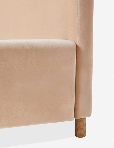 #color::buff #size::queen #size::king #size::cal-king | Close-up of where the headboard, oak leg, and base of the Solene buff pink velvet platform bed meet