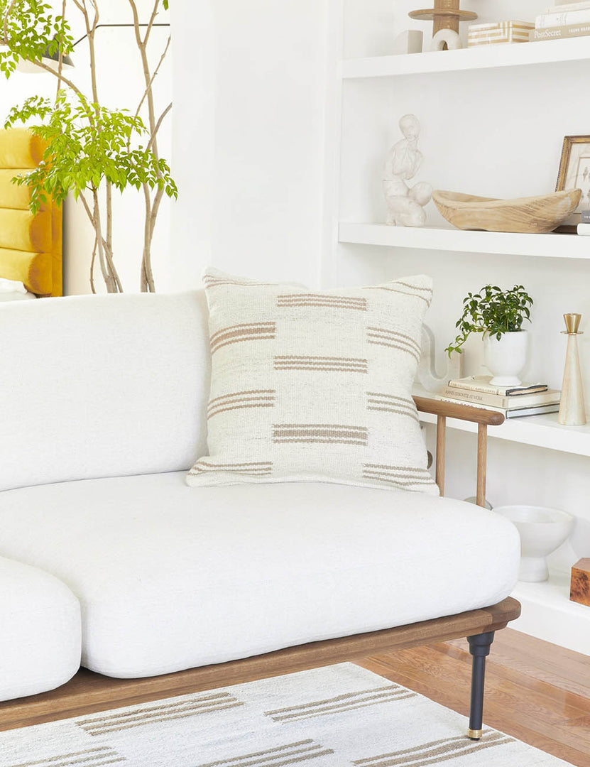#style::square | Stripe break natural and cream square pillow by Sarah Sherman Samuel sits on a white couch in a living room with a stripe break carpet