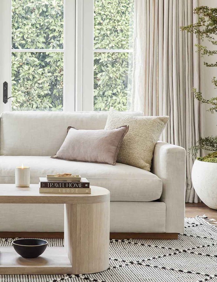 #color::oatmeal #size::20--x-20- | The Manon linen oatmeal cream square boucle pillow sits on a white sofa in a living room with a black and white patterned rug