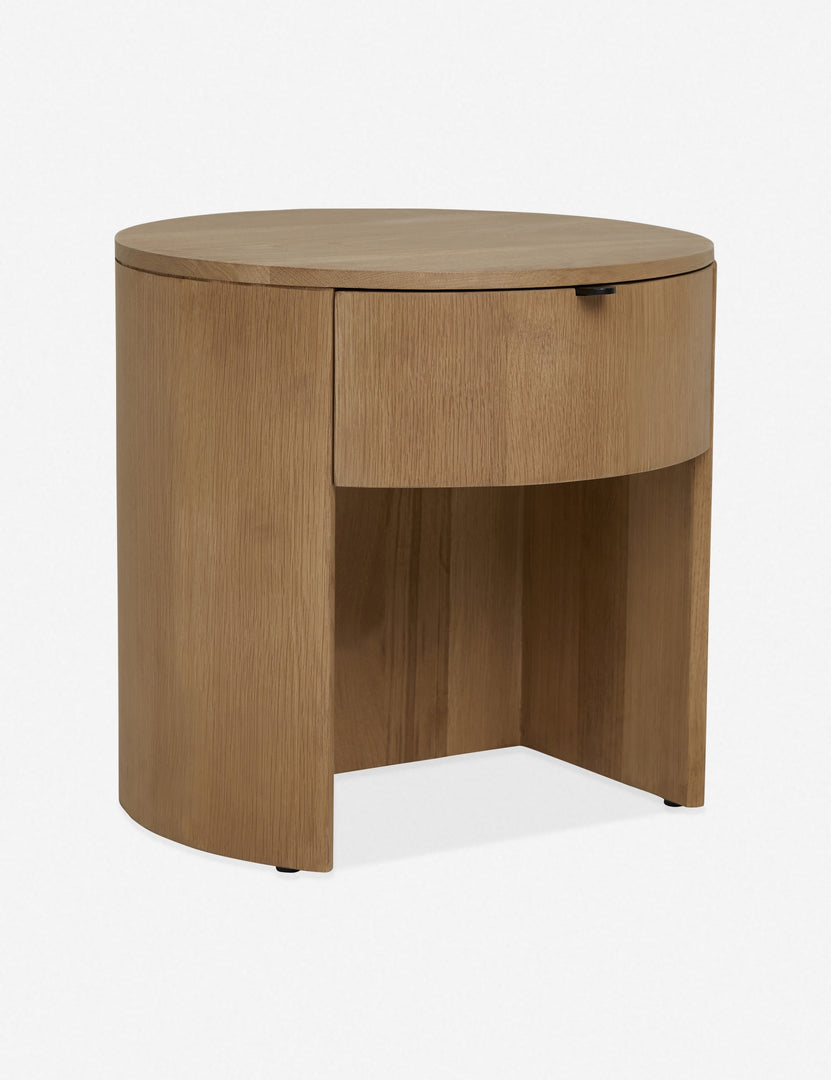 | Angled left view of the Kono round solid oak nightstand with one drawer