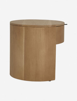 Side view of the Kono round solid oak nightstand with one drawer