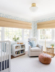 #showall::39489938817123 | The Randi curved brass Flush Mount Light with domed glass cover is mounted in a nursery with floral wallpaper, white furniture, and a leather ottoman