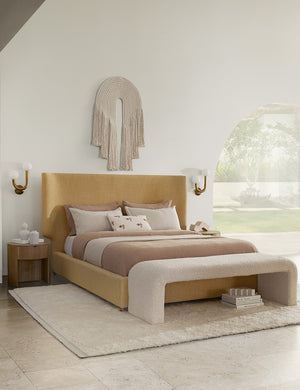 The European Flax Linen natural Sheet Set by Cultiver is tucked into a golden linen framed bed in a bedroom with dusk pink linens, a woven white rug, and a cream boucle bench