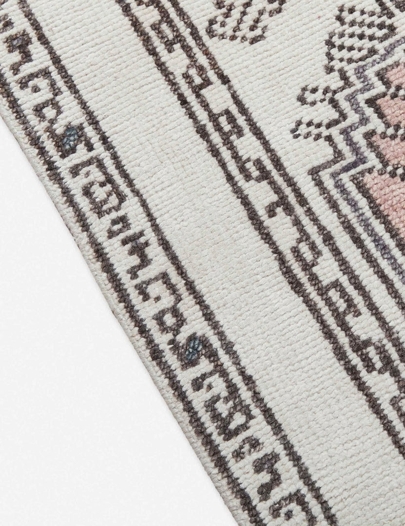 #size::2-6--x-8- | Close-up of the edge of the Zehra hand-knotted ivory, gray and purple medallion wool-blend area rug
