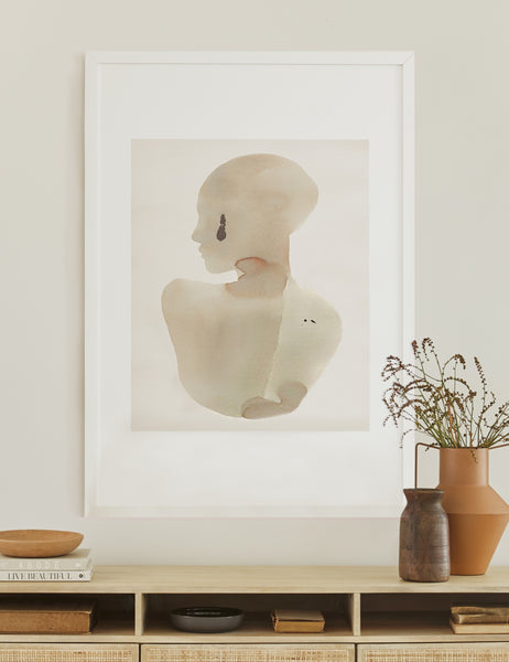 #color::white #size::3225--x-4725- #size::3825--x-5625- | The Sara singh back drop portrait neutral toned wall art by Stampa sits atop a white wooden sideboard with earth-toned bowls and vases